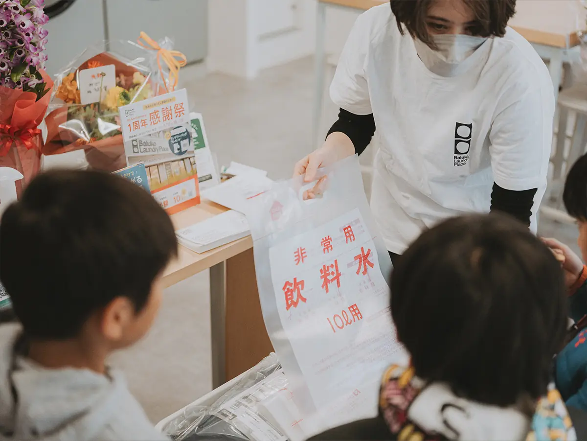 備蓄品の飲料水補給袋を見ている子どもたち